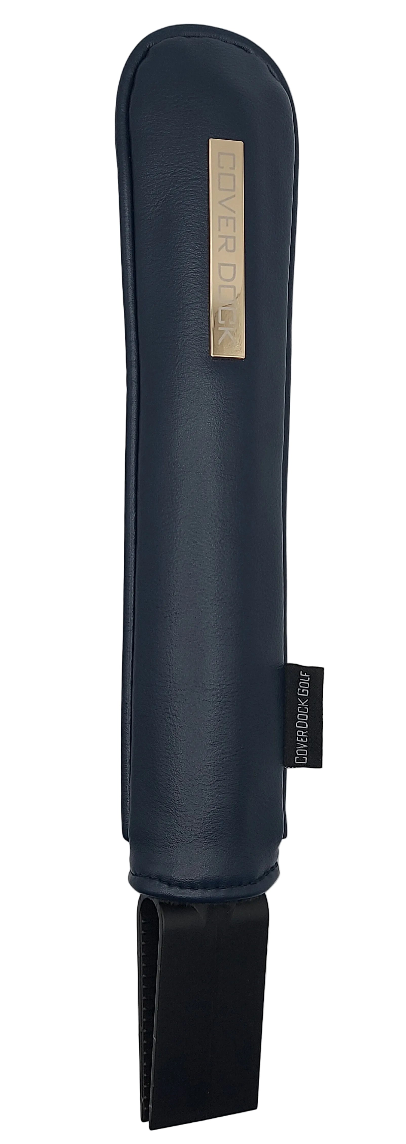 A dark navy blue leather or faux-leather sleeve or cover with a vertical gold-toned metal plate reading 'COVER DOCK' and a small black side tag, shown against a light gray background.